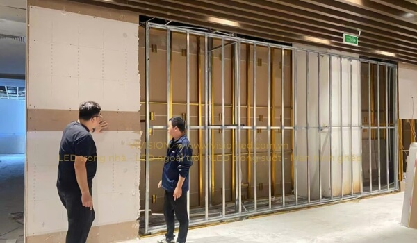 Kỹ thuật viên kiểm tra hệ thống khung thép gia cố cho màn hình LED lắp đặt tại công trình